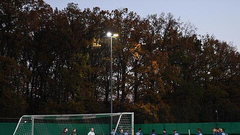 Zum Training hat Bundestrainer Flick die Mannschaft im Halbkreis vor einem Tor versammelt.
