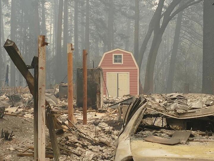 Ein ausgebranntes Fahrzeug und Trümmer nach den Waldbränden in Paradise.