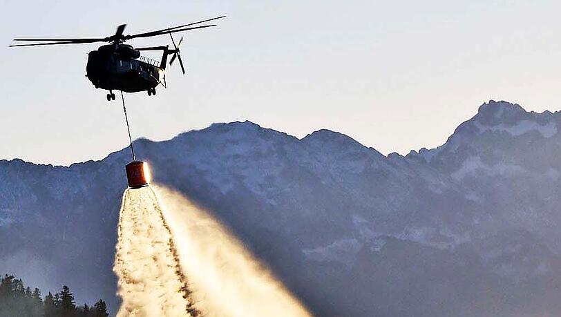 Ein Hubschrauber beim Löschen der Flammen. Ein Hubschrauber beim Löschen der Flammen.