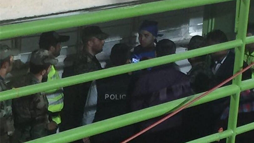 Das Bild zeigt die verhaftete Frau im blauen Trikot und blauem Tuch auf dem Kopf.