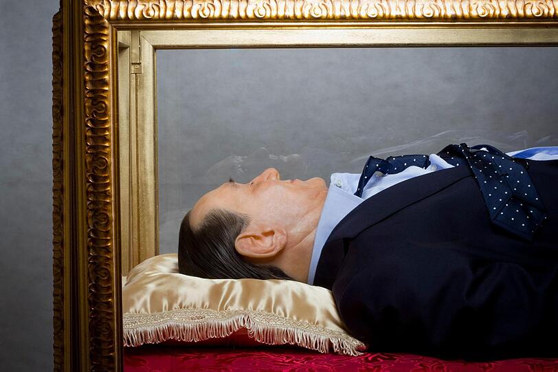 Wie ein Heiliger - oder wie Mao und Lenin? - Eine Wachsfigur von Silvio Berlusconi aufgebahrt in einem Glassarg.