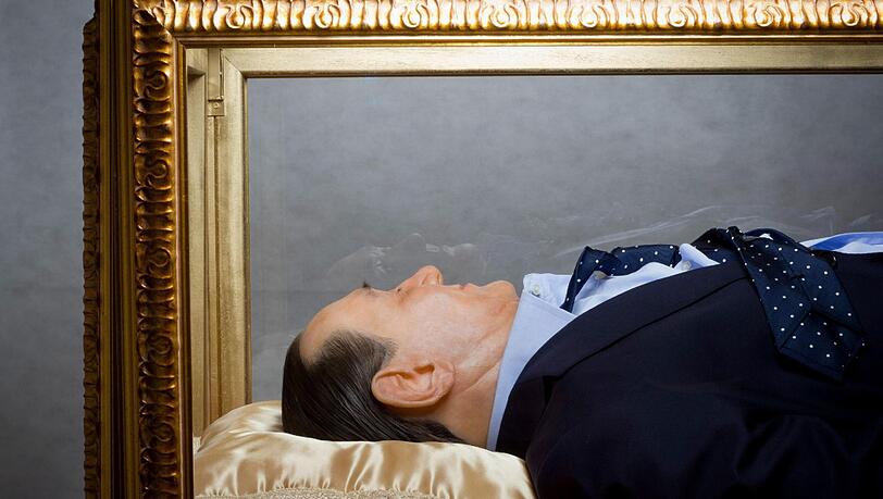 Wie ein Heiliger - oder wie Mao und Lenin? - Eine Wachsfigur von Silvio Berlusconi aufgebahrt in einem Glassarg. Wie ein Heiliger - oder wie Mao und Lenin? - Eine Wachsfigur von Silvio Berlusconi aufgebahrt in einem Glassarg.