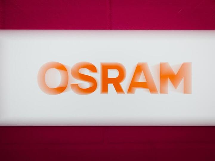Die roten Buchstaben des Osram-Logos sind auf weißem und rotem Hintergrund zu sehen. Foto: Matthias Balk/dpa/Archivbild