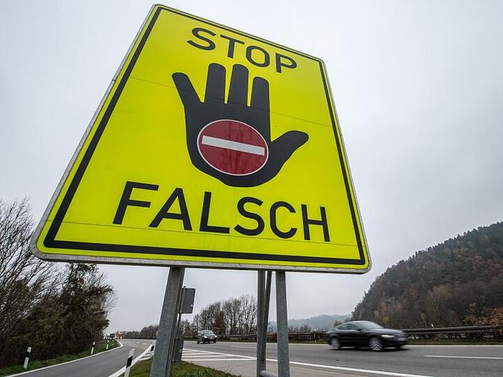 Ein Schild mit der Aufschrift "STOP FALSCH" steht an der Autobahn A3. Foto: Armin Weigel/dpa/Archivbild