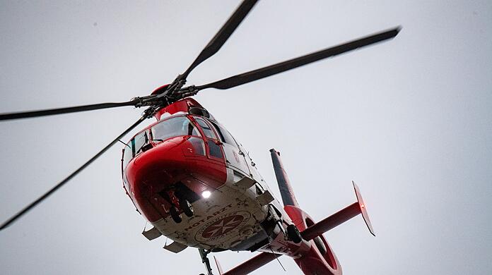 Ein Rettungshubschrauber setzt zur Landung auf dem Flugplatz einer Klinik an.