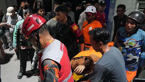 Retter tragen eine Frau auf einer Trage.