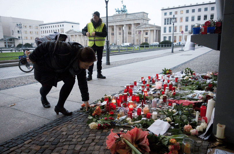 In Berlin legen Pasanten Kerzen und Blumen nieder.