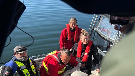 Helfer besteigen ein Boot, um zum Wal hinauszufahren.