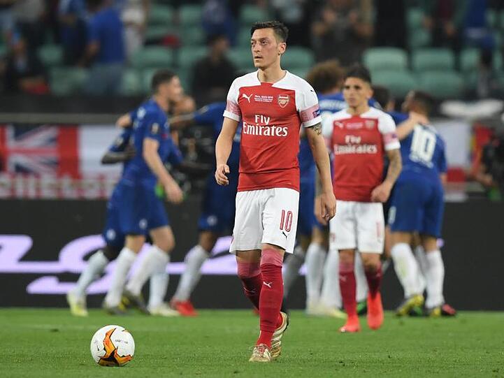 Während die Chelsea-Profis das Tor zum 1:0 feiern, schaut Arsenals Mesut Özil enttäuscht drein.