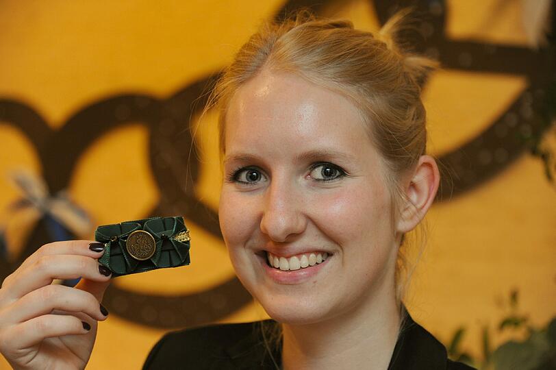 Teilnehmerin Svenja zeigt stolz ihre selbstgemachte Brosche.