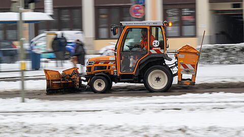 Ein Schneeräumfahrzeug der Stadtreinigung fährt über einen verschneiten Gehweg im Stadtteil Haidhausen. Nach dem Eisregen haben am Donnerstag Schneefälle in Bayern für Verkehrsbehinderungen gesorgt. Die Polizei registrierte zahlreiche Unfälle, bei denen es zwar meistens bei Blechschäden blieb, es gab aber auch einige Verletzte.