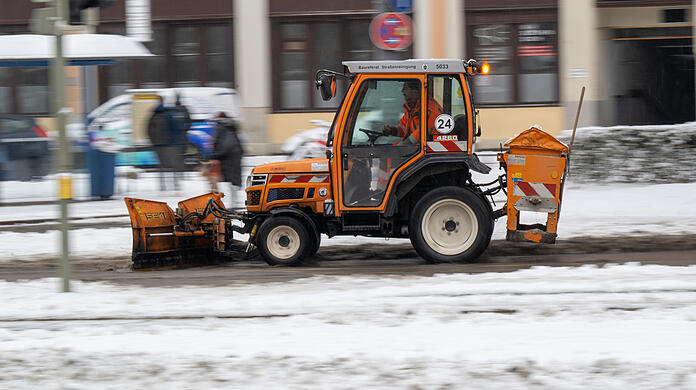 Ein Schneeräumfahrzeug der Stadtreinigung fährt über einen verschneiten Gehweg im Stadtteil Haidhausen. Nach dem Eisregen haben am Donnerstag Schneefälle in Bayern für Verkehrsbehinderungen gesorgt. Die Polizei registrierte zahlreiche Unfälle, bei denen es zwar meistens bei Blechschäden blieb, es gab aber auch einige Verletzte.