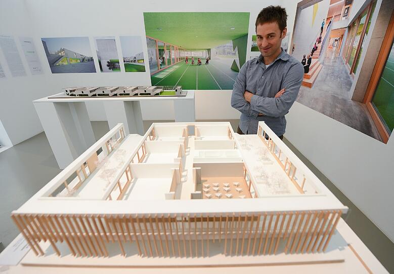 Johannes Talhof vom Architekturbüro Hess Talhof Kusmierz im Deutschen Architekturmuseum (DAM) in Frankfurt am Main mit einem Modell der Grundschule am Arnulfpark in München.