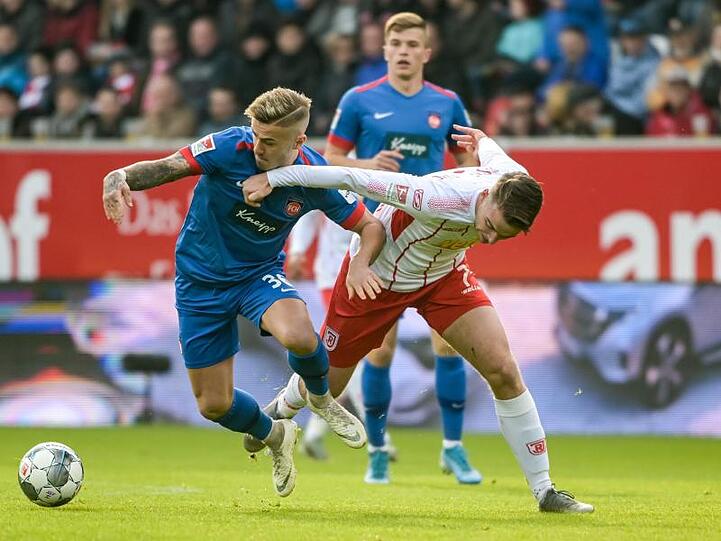 Niklas Dorsch von Heidenheim (l.) und Regensburgs Max Besuschkow kämpfen um den Ball. Foto: Armin Weigel/dpa