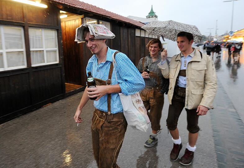 Trotz Sauwetter und Regen warten bereits viele Wiesngänger auf den Wiesnanstich. Der Kampf um den Platz im Bierzelt beginnt schon am frühen Morgen. Die ersten Bilder.