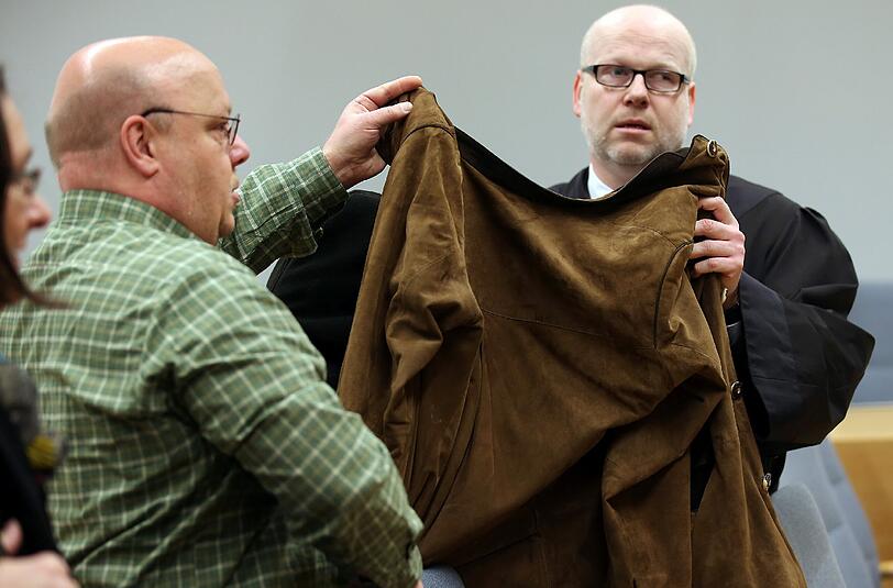 Eine 32 Jahre alte Frau wird von ihrem Anwalt Daniel Nierenz (r) und einem Anwaltsgehilfen (l) mit einer Jacke verdeckt. Die Frau muss sich vor dem Landgericht wegen des Todes ihrer beiden Kinder verantworten.