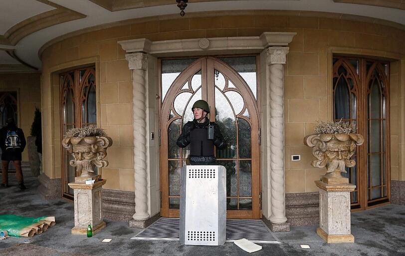 Ein Demonstrant bewacht den Einganz zur Villa des abgesetzte Präsident der Ukraine, Viktor Janukowitsch. Demonstranten haben seine Prunk-Residenz eingenommen und für die Öffentlichkeit zugänglich gemacht. Die Bilder.