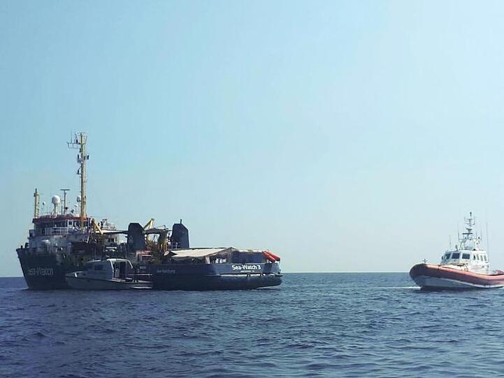 Ein Boot der italienischen Küstenwache patrouilliert neben dem Rettungsschiff "Sea-Watch 3" vor der Küste der süditalienischen Insel Lampedusa.