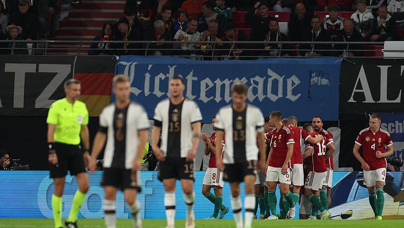 Ungarns Spieler jubeln im Hintergrund - im Vordergrund drei deutsche Nationalspieler.