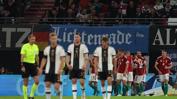 Ungarns Spieler jubeln im Hintergrund - im Vordergrund drei deutsche Nationalspieler.