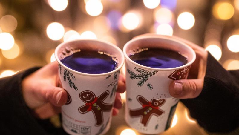 Zwei Frauen stoßen mit Glühwein an.
