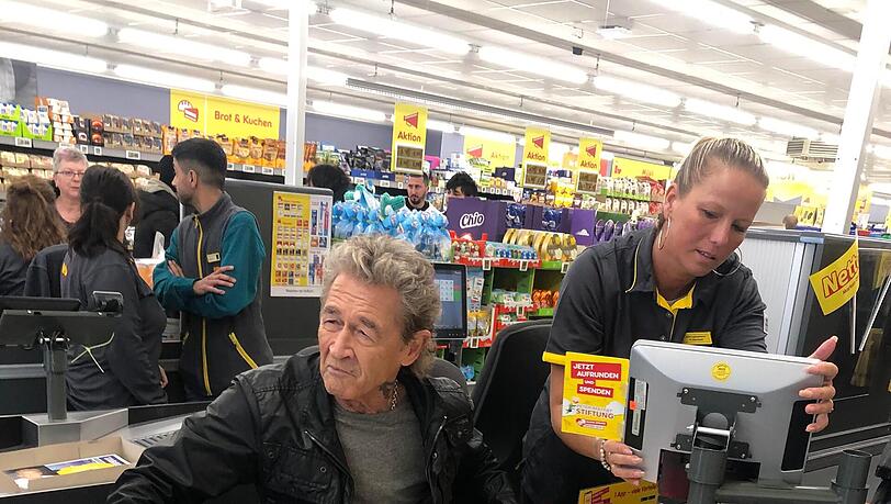 Kassentrainerin Edina Heuwieser (rechts) weist Musik-Superstar Peter Maffay in die Arbeit an der Supermarkt-Kasse ein. Kassentrainerin Edina Heuwieser (rechts) weist Musik-Superstar Peter Maffay in die Arbeit an der Supermarkt-Kasse ein.