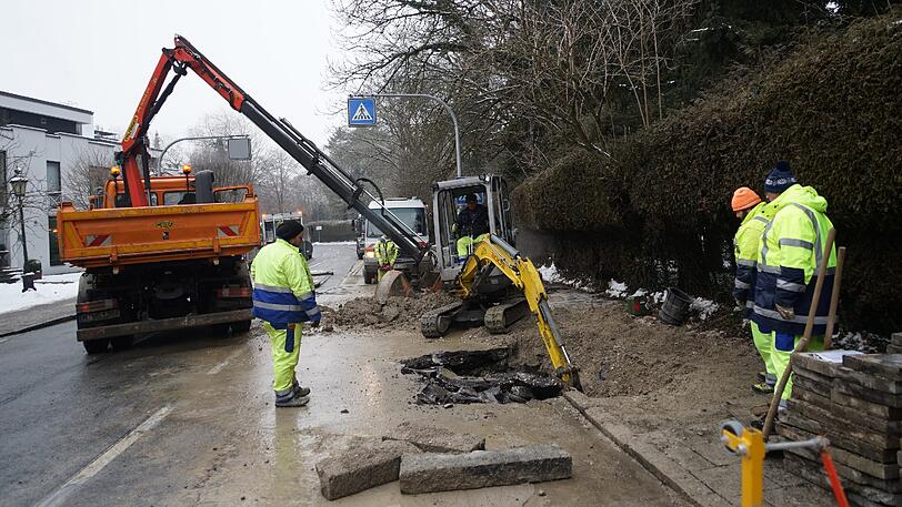 Mitarbeiter der Stadtwerke flicken das Loch in der Straße. Zuvor lief ordentlich Wasser auf die Fahrbahn.