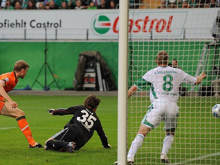 Wolfsburgs Torwart Hitz (M) kann den Ball von Werders Mertesacker (l) nicht halten.