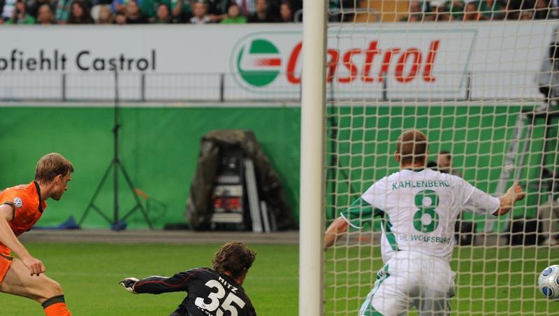 Wolfsburgs Torwart Hitz (M) kann den Ball von Werders Mertesacker (l) nicht halten. Wolfsburgs Torwart Hitz (M) kann den Ball von Werders Mertesacker (l) nicht halten.