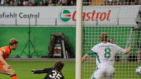 Wolfsburgs Torwart Hitz (M) kann den Ball von Werders Mertesacker (l) nicht halten.