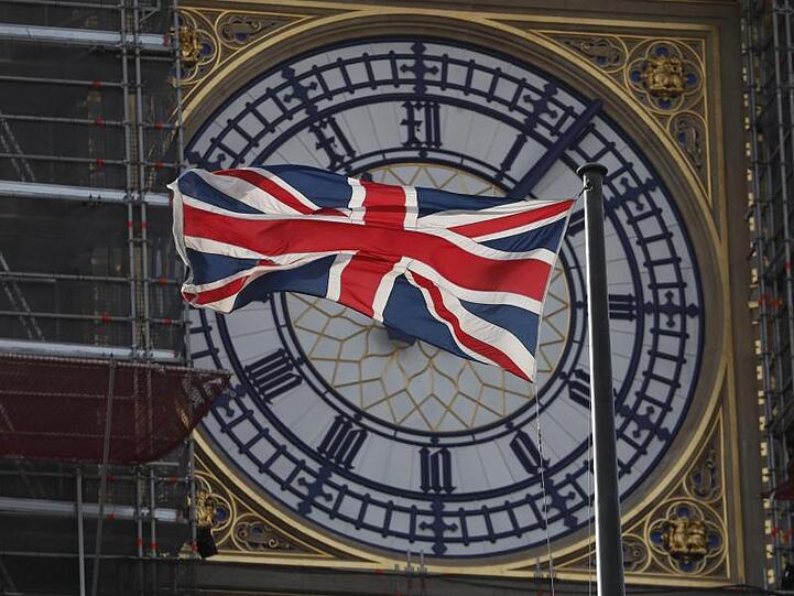 Die Nationalflagge des Vereinigten Königreichs Großbritannien und Nordirland, weht vor dem Zifferblatt des Queen Elizabeth Tower, in dem sich die als "Big Ben" bekannte Glocke befindet, die zu den "Houses of Parliament" gehört.