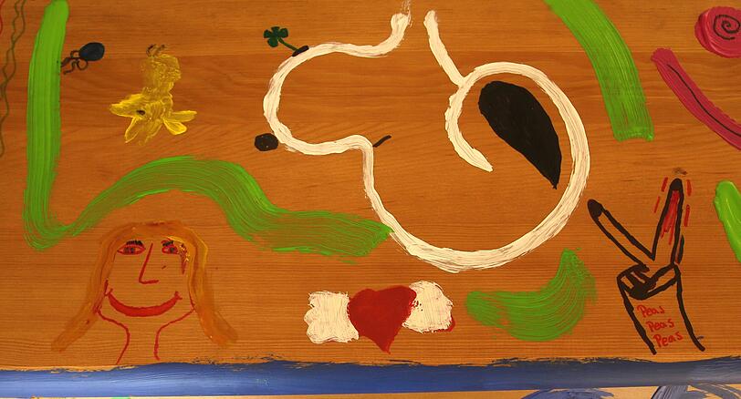 Ein Kind hat ein lachendes Gesicht auf den Holzsarg gemalt.