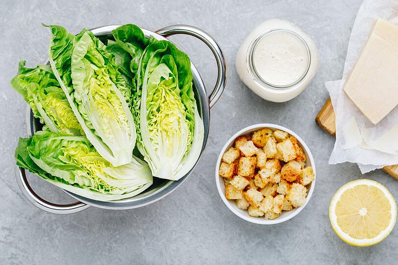F&uuml;r den einfachen, aber sehr aromatischen Zitronen-Parmesan-Salat hacken Sie zuerst einen gro&szlig;en Kopfsalat oder alternativ drei Salatherzen in mundgerechte St&uuml;cke. F&uuml;r das Dressing verr&uuml;hren Sie 60 Milliliter Oliven&ouml;l, den Saft von zwei gro&szlig;en Zitronen und 80 Gramm fein geriebenen Parmesan. Mit Salz und frisch gemahlenem schwarzen Pfeffer abschmecken.
