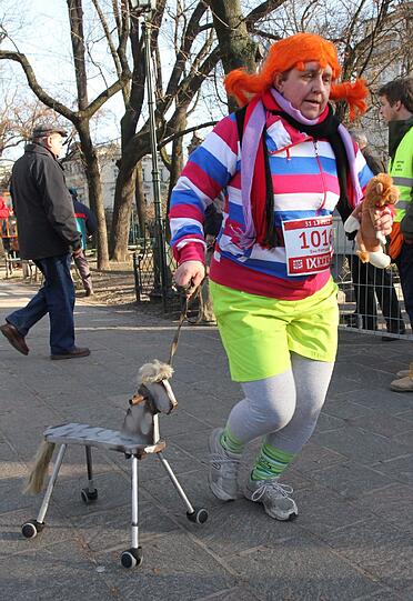 Im polnischen Krakau findet jedes Jahr der Silvester-Lauf statt. Hier eine Teilnehmerin mit Holzpferd und Kuscheltier.
