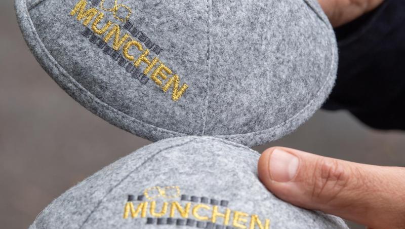 Zwei graue Kippot tragen die in gelben Buchstaben gehaltene Aufschrift "München". Foto: Peter Kneffel Zwei graue Kippot tragen die in gelben Buchstaben gehaltene Aufschrift "München". Foto: Peter Kneffel