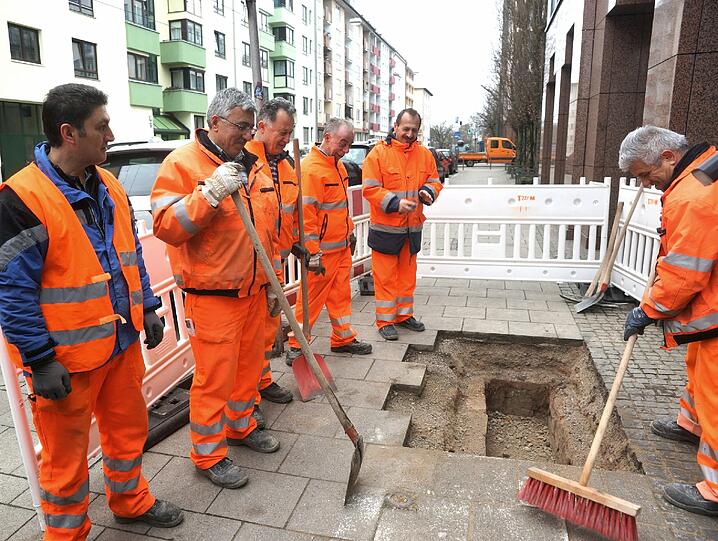 Mitarbeiter des Baureferats verfüllen den Schacht mit Kies und Beton.