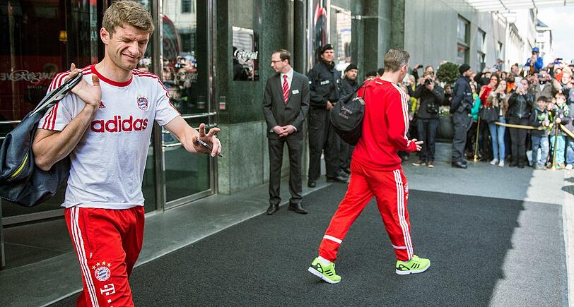 Müde Bayern-Spieler schleppen sich nach einer kurzen Nacht zum Mannschaftsbus.