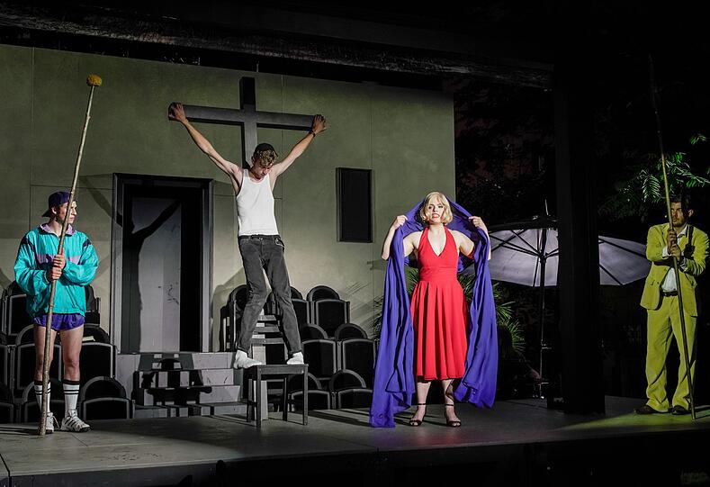 Ein Hauch von Oberammergau im Garten des Volkstheaters: Regie-Assistent Goldberg (Mauricio Hölzemann) spielt Jesus am Kreuz, Schauspielerin Terese Tormentina (Luise Deborah Daberkow) die Mutter Gottes Maria. Komplettiert werden die kleinen Passionsspiele durch die Statisten Masch (Cengiz Görur, li.) und Raamah (Timocin Ziegler, re.)