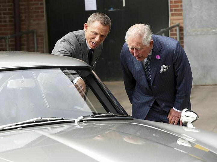 Daniel Craig (l) zeigt Prinz Charles (r) den Aston Martin DB5.
