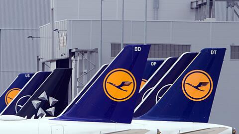 Passagiermaschinen der Fluggesellschaft Lufthansa stehen auf einem Flughafen.