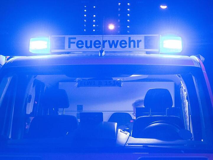 Ein Einsatzfahrzeug der Feuerwehr mit eingeschaltetem Blaulicht.