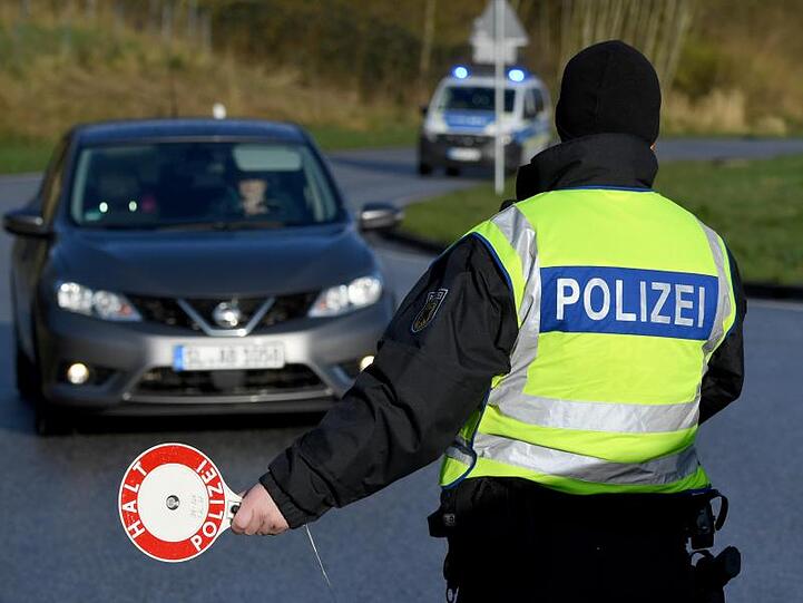 Ein Beamter der Bundespolizei steht an der deutsch-dänischen Grenze an einem Kontrollpunkt.