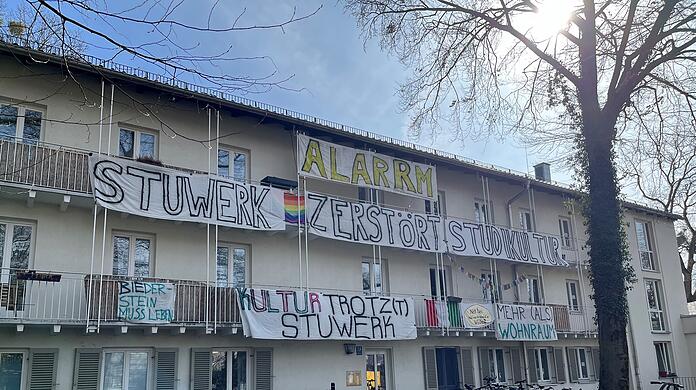 Studierende protestieren mit Bannern gegen geplante Neuerungen.