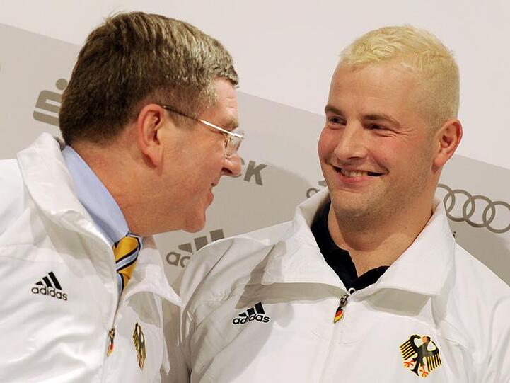 Thomas Bach (l) und André Lange verkünden, dass Lange die deutsche Fahne tragen wird.