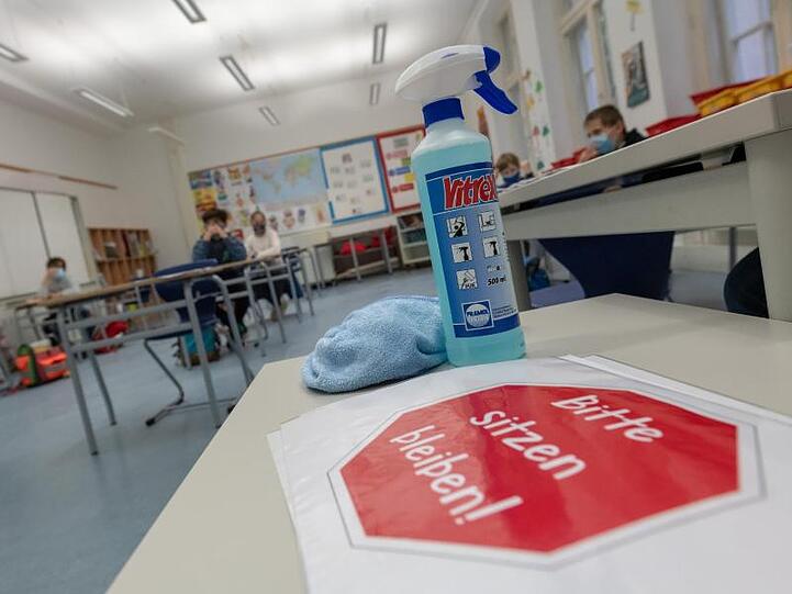 Desinfektionsmittel steht auf einem Tisch in einem Klassenzimmmer. Foto: Peter Kneffel/dpa/Symbolbild