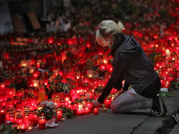 Trauer am Ort des Geschehens: Eine junge Frau stellt eine Kerze ab, wo am Samstag die Katastrophe ihren Lauf nahm
