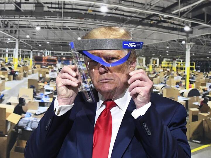 Donald Trump hält während des Rundgangs in einem Ford-Werk ein Gesichtsvisier in den Händen - einen Mundschutz trug er trotz Aufforderung nicht.