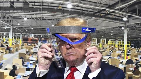 Donald Trump hält während des Rundgangs in einem Ford-Werk ein Gesichtsvisier in den Händen - einen Mundschutz trug er trotz Aufforderung nicht.