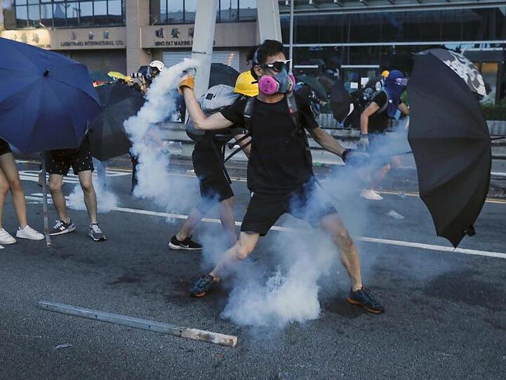 Ein Demonstrant wirft einen Tränengasbehälter, der von der Polizei abgefeuert wurde.