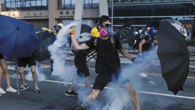 Ein Demonstrant wirft einen Tränengasbehälter, der von der Polizei abgefeuert wurde. Ein Demonstrant wirft einen Tränengasbehälter, der von der Polizei abgefeuert wurde.